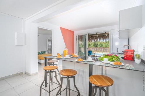 a kitchen with a counter and stools in a room at Villa Sunrays in Sainte-Anne
