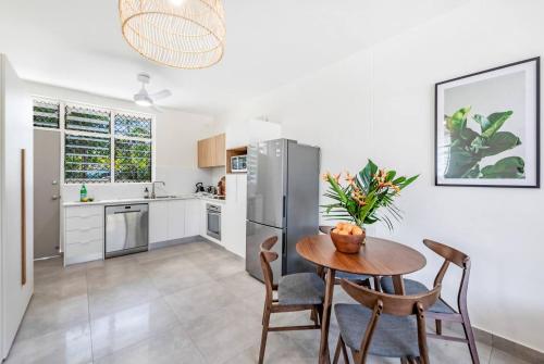 a kitchen with a table and chairs and a refrigerator at 'Botanica Bonita' A Stylish Nightcliff Hideaway in Nightcliff