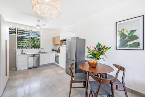 a kitchen with a table and chairs and a refrigerator at 'Botanica Bonita' A Stylish Nightcliff Hideaway in Darwin