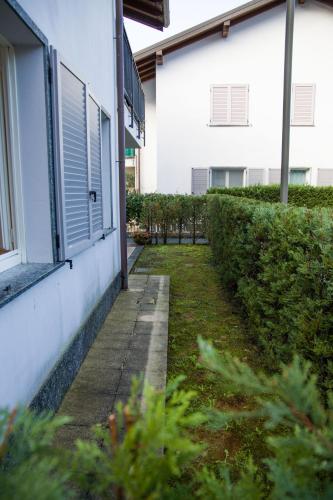 a sidewalk next to a building with a hedge at Appartamento con giardino e parcheggio privato in Bellagio