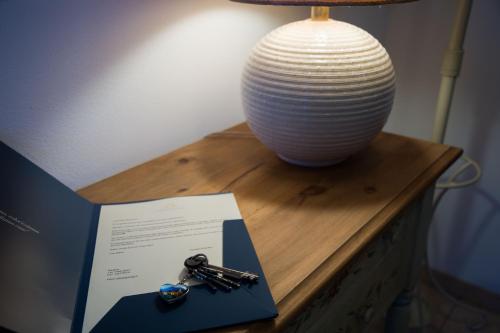 a table with a lamp and a vase on it at Appartamento con giardino e parcheggio privato in Bellagio