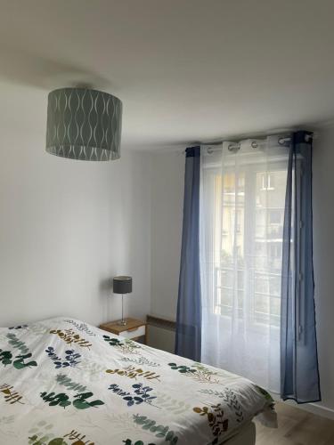1 dormitorio con cama y ventana en Maison agréable et spacieuse aux portes de Paris et du métro en Saint-Ouen