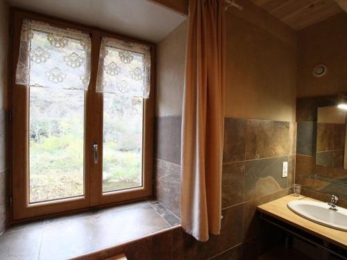 une salle de bain avec un lavabo et une fenêtre dans l'établissement Gîte spacieux avec terrasse surplombant rivière, idéale pour pêche et sports d’eau, tout inclus - FR-1-582-17, à Saint-Julien-des-Chazes