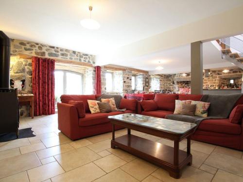 a living room with red couches and a coffee table at Gîte familial restauré avec jardin clos, équipements bébé, animaux acceptés, proche St-Julien-Chapteuil - FR-1-582-296 in Saint-Julien-Chapteuil