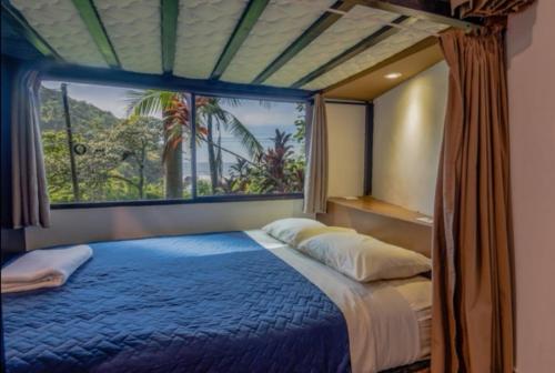 a bedroom with a blue bed with a large window at Lagarza Hostel in La Libertad