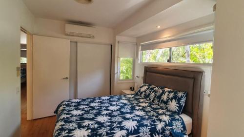 a small bedroom with a bed and a window at Ibis 3 House in Rainbow Beach