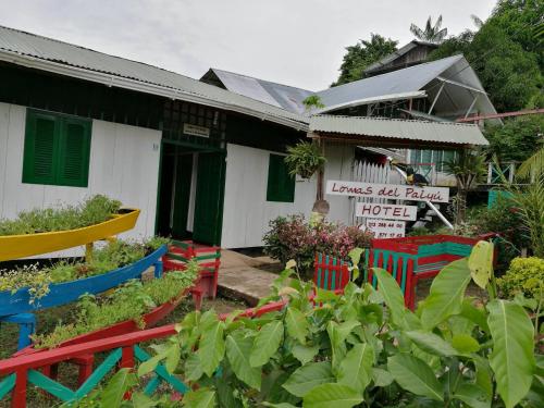 un jardín con sillas coloridas frente a una casa en Hotel Lomas del Paiyü, en Puerto Nariño