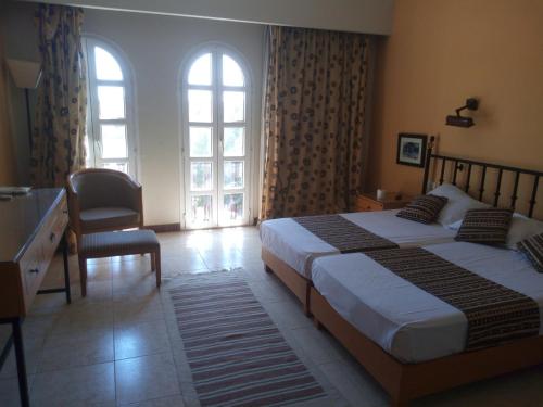 um quarto com 2 camas, uma secretária e 2 janelas em EL Gouna Abu tig marina studio em Hurghada