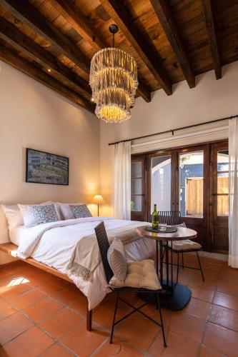 a bedroom with a large bed and a chandelier at Rooftop Jacuzzi! Country-style 4 Bedroom Cottage in San Miguel de Allende