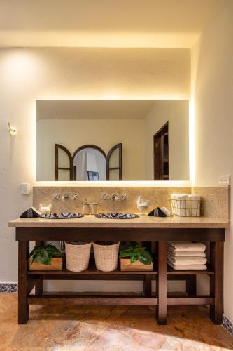a bathroom with a sink and a large mirror at Rooftop Jacuzzi! Country-style 4 Bedroom Cottage in San Miguel de Allende