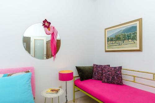 a living room with a pink couch and a mirror at Apartments Vesela in Podaca