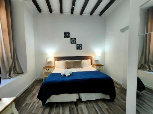 a bedroom with a bed with a blue blanket at Zaida Boutique Hotel in Seville