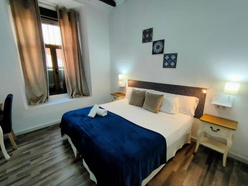 a bedroom with a bed and a desk and a window at Zaida Boutique Hotel in Seville