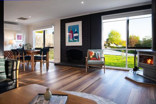 a living room with a fireplace and a dining room at Indus- a bright and welcoming home in Daylesford