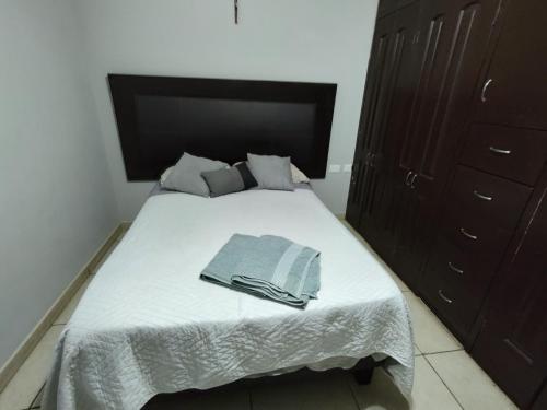 a bedroom with a bed with a towel on it at La Quinta Departamentos in Hermosillo