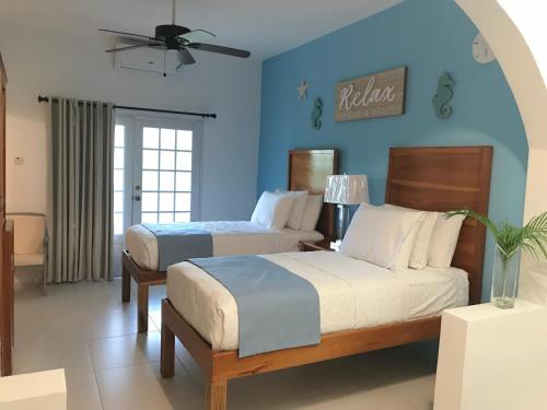 1 dormitorio con 2 camas y pared azul en Sommerville Resorts, en Negril