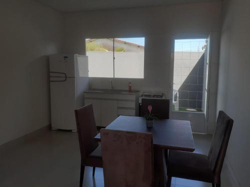 eine Küche mit einem Tisch und Stühlen sowie einem Kühlschrank in der Unterkunft Casa Nova confortavel e aconchegante 1 in Chapada dos Guimarães