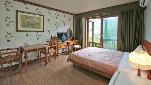 a bedroom with a bed and a desk and a deskablish at Chalet Resort in Pyeongchang 