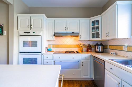 a white kitchen with white cabinets and a table at The Estate at Mt Dora in Mount Dora