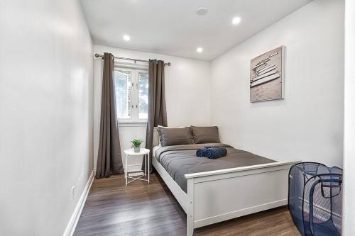 a bedroom with a bed in a room with a window at Bungalow-3 Car Parking-PingPong-BigDeck-BBQ-Close to 403-Appleby Go in Burlington