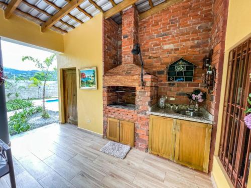 - une cuisine avec un mur en briques et un évier dans l'établissement Villa Rosalía Jarabacoa con Piscina Climatizada, à Jarabacoa