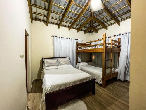 a bedroom with two beds and a bunk bed at Villa Rosalía Jarabacoa con Piscina Climatizada in Jarabacoa