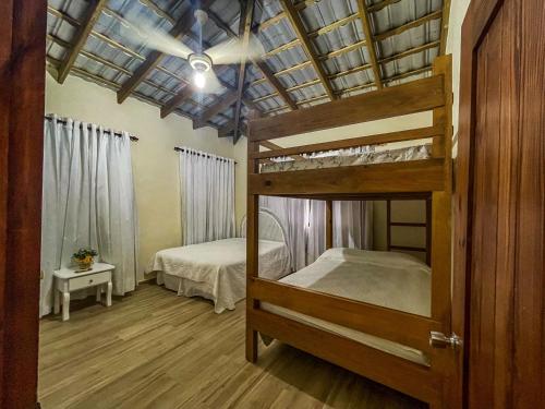 ein Zimmer mit einem Etagenbett und ein Schlafzimmer mit einem Bett m2 in der Unterkunft Villa Rosalía Jarabacoa con Piscina Climatizada in Jarabacoa