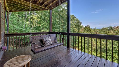 a screened in porch with a bench and a swing at Finding Grace in Blue Ridge