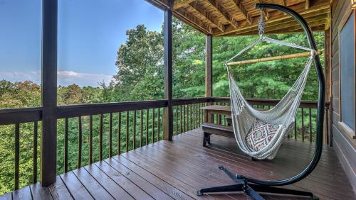 a hammock on a screened in porch with a bench at Finding Grace in Blue Ridge