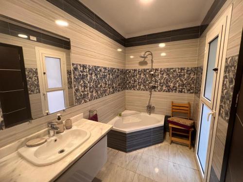a bathroom with a tub and a sink and a bath tub at Beautiful appartement. In Cairo Madinaty in Cairo