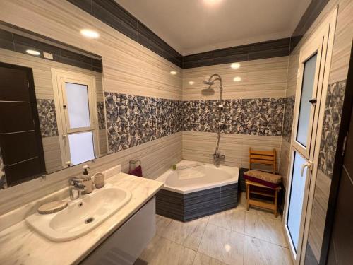 a bathroom with a tub and a sink and a bath tub at Beautiful appartement. In Cairo Madinaty in Cairo