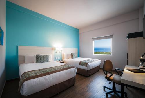 a hotel room with two beds and a window at Comfort Inn & Suites Los Cabos in Cabo San Lucas