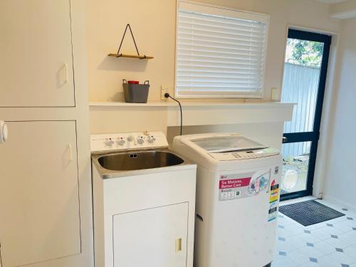 a small kitchen with a sink and a refrigerator at Habour View - Tauranga Central in Tauranga