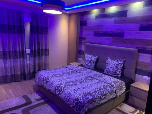 um quarto com uma cama roxa num quarto com cortinas em Luxury Appartement Marina Agadir em Agadir
