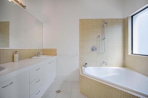 een badkamer met een bad, een wastafel en een douche bij Ocean View Villa Marco @ Marcus Beach in Marcus Beach