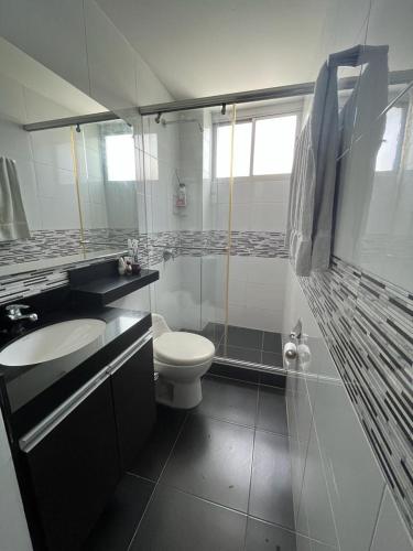 a white bathroom with a toilet and a sink at Apartamento Amoblado Villeta in Villeta