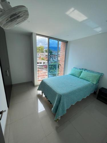 a bedroom with a bed and a large window at Apartamento Amoblado Villeta in Villeta