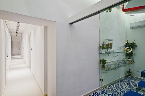 un pasillo con una puerta de cristal con plantas. en Il Reticolo, en Salerno