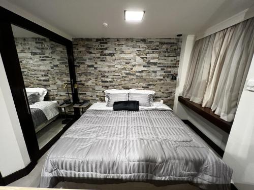 een slaapkamer met een bed en een bakstenen muur bij Flat - Al Santos - Prox Av Paulista in Sao Paulo