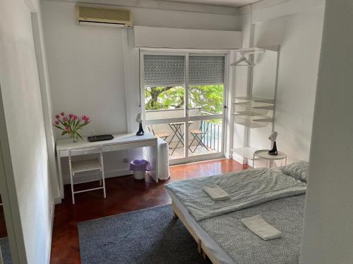 een slaapkamer met een bed, een bureau en een raam bij L83 - rooms and apartments in Lissabon