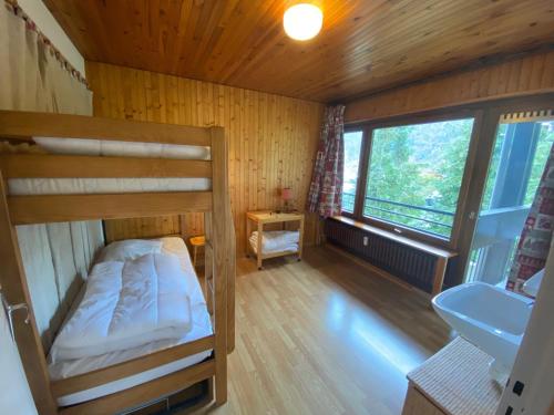 Cette petite chambre comprend des lits superposés et un lavabo. dans l'établissement Appartement au centre de La Clusaz avec balcon, ascenseur et casier à skis - FR-1-459-197, à La Clusaz