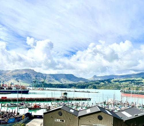 un puerto deportivo con barcos en el agua y las montañas en Sea views in luxury at LYTTELTON BOATIQUE HOUSE - 14 km from Christchurch en  Lyttelton