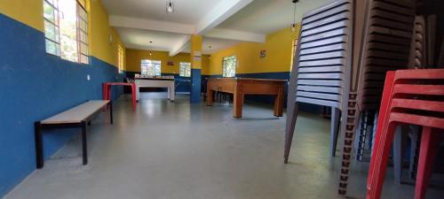 an empty room with a piano and tables and chairs at Chácara Sorriso 1 em Atibaia in Atibaia