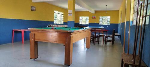a room with a pool table and some tables and chairs at Chácara Sorriso 1 em Atibaia in Atibaia