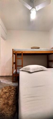 a bedroom with a bed and a desk with a fan at Chácara Sorriso 1 em Atibaia in Atibaia
