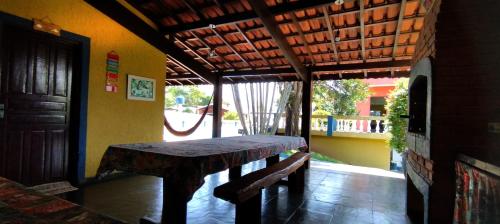 a wooden table and bench in a room with a porch at Chácara Sorriso 1 em Atibaia in Atibaia