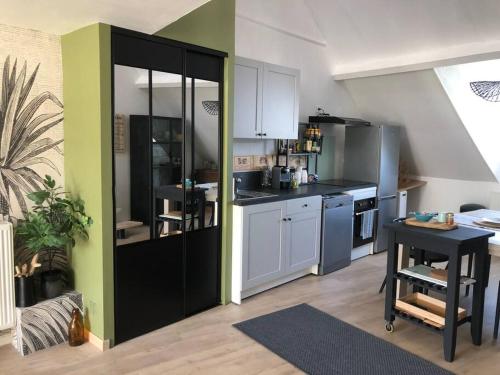a kitchen with white cabinets and a table in a room at Le petit St-Jean in Bagnères-de-Bigorre