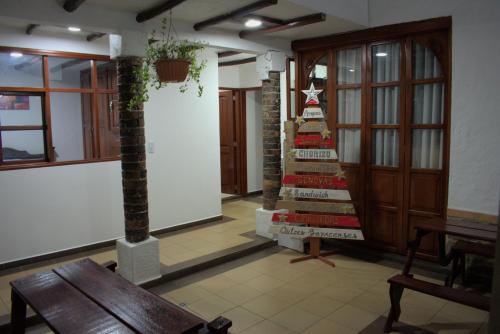 a room with a wooden table and a christmas tree at Hospedaje Iraca - Pueblito Boyacense Duitama in Duitama