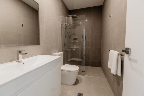 W łazience znajduje się umywalka, toaleta i prysznic. w obiekcie Beach & Bay Stay Motel w mieście Callala Beach