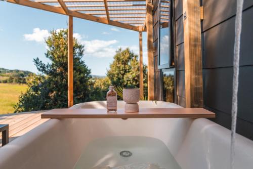 a bath tub with a view from a house at Koa Cabin Hahei in Hahei